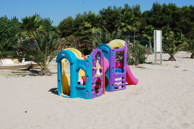 Un piccolo scivolo colorato su una spiaggia sabbiosa.