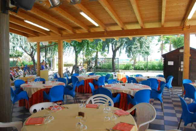 Ristorante all'aperto con tavoli apparecchiati.
