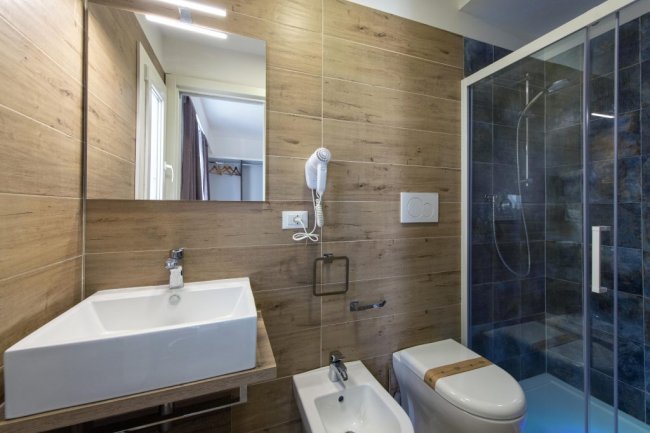 Elegante bagno con doccia e pareti effetto legno.