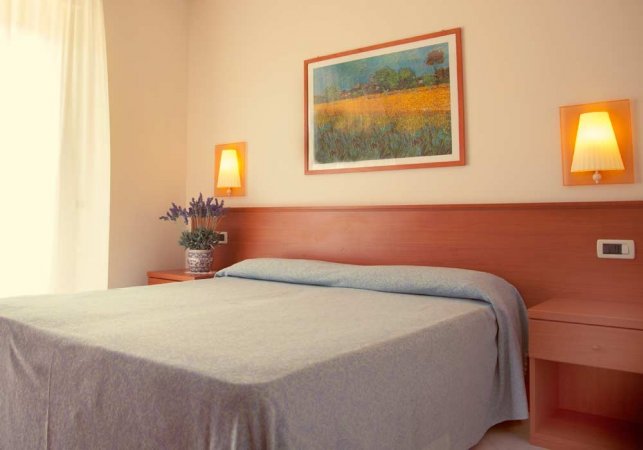 Camera da letto con letto matrimoniale e quadro sopra.