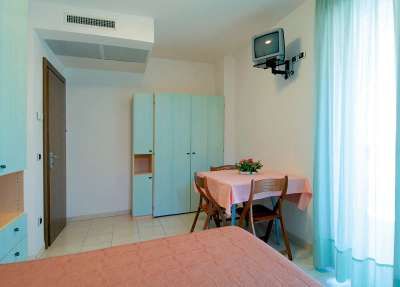 Camera con armadio, tavolo e TV.