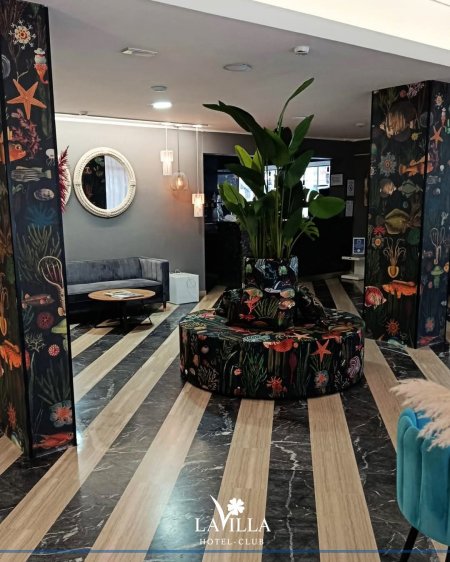 Lobby con piante e arredi eleganti.