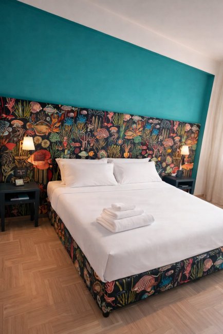 Letto matrimoniale con testiera floreale e lenzuola bianche.