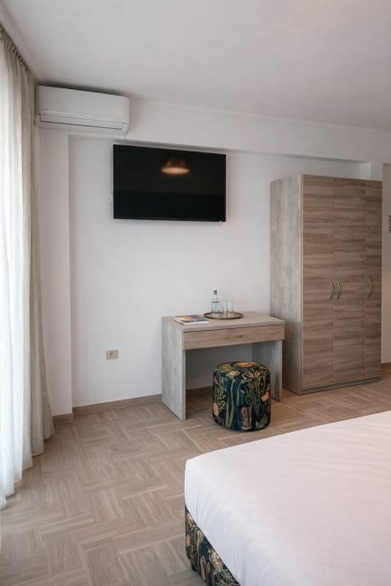 Angolo TV con armadio e pouf colorato.