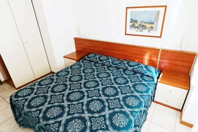 Camera da letto con letto matrimoniale e armadio.